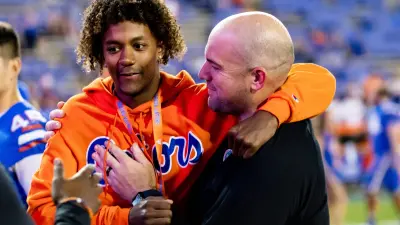 Florida Gators offensive coordinator Rob Sale hugs Florida Gators recruit Jaden Rashada after the game against the South Carolina Gamecocks at Steve Spurrier Field at Ben Hill Griffin Stadium in Gainesville