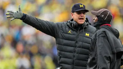 Michigan coach Jim Harbaugh talks to referee regarding a play against Indiana during the first half of U-M's 52-7 win over Indiana on Saturday