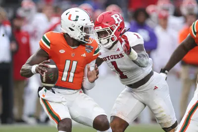 Dec 28, 2023; Bronx, NY, USA; Miami Hurricanes quarterback Jacurri Brown (11) is sacked by Rutgers Scarlet Knights linebacker Mohamed Toure (1) during the first half of the 2023 Pinstripe Bowl at Yankee Stadium.