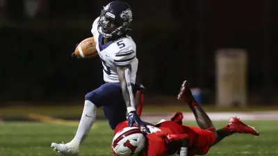 Naples Golden Eagles running back Shawn Simeon (5) stiff arms an Immokalee Indians defender while running the ball during the second quarter of a game at Gary Bates Stadium in Immokalee on Friday