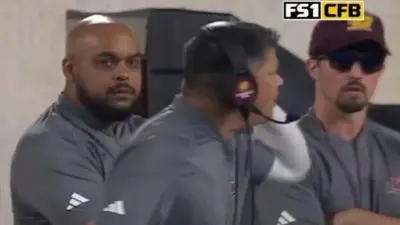 This image from an FS1 broadcast of the Central Michigan-Michigan State game on Sept. 1 shows a man (at right) resembling Michigan staffer Connor Stalions on the Chippewas' sideline wearing CMU gear and wearing a "VB" (visitors bench) credential. FS1