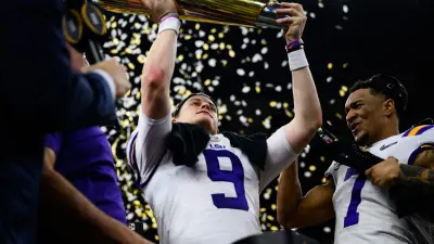 LSU quarterback Joe Burrow (9) holds up the trophy after their victory against Clemson at the College Football National Championship game at the Mercedes Benz Superdome Monday