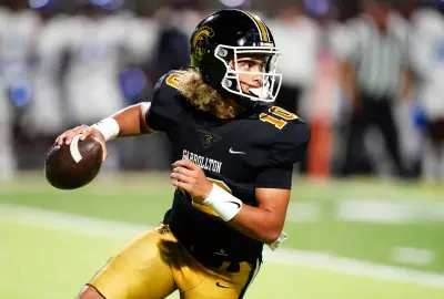 Oct 20, 2023; Carrollton, GA, USA; Carrollton Trojans quarterback Julian Lewis (10) scrambles out of the pocket against the Westlake Lions during the first half at Grisham Stadium.