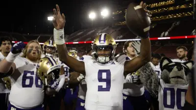 Washington Huskies quarterback Michael Penix Jr. (9) and his teammates celebrate their victory over the Stanford Cardinal.