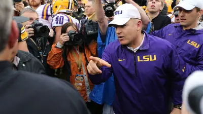 Louisiana State coach Les Miles meets with Iowa coach Kirk Ferentz following Miles and LSU's 21-14 win over the Hawkeyes on Wednesday