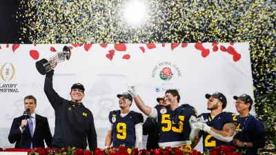 Michigan head coach Jim Harbaugh lifts up the Rose Bowl trophy after 27-20 win over Alabama at Rose Bowl Stadium in Pasadena
