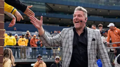 ESPN College Game Day's Pat McAfee high-fives fans as he takes the field before the game between Michigan and Texas at Michigan Stadium in Ann Arbor on Saturday