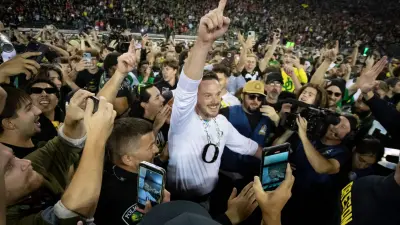 Oregon Ducks head coach Dan Lanning celebrates amid a crowd of fans on the field as the No. 3 Oregon Ducks knock off the No. 2 Ohio State Buckeyes 32-31 Saturday