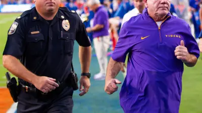 LSU Tigers head coach Brian Kelly runs off the field after the first half at Ben Hill Griffin Stadium in Gainesville
