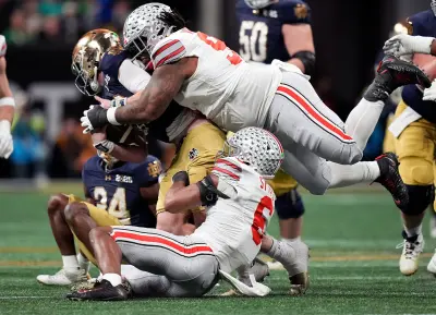 Ohio State Buckeyes safety Sonny Styles (6) and defensive tackle Tyleik Williams (91) sacks Notre Dame Fighting Irish quarterback Riley Leonard (13) in the third quarter during the College Football Playoff championship at Mercedes-Benz Stadium in Atlanta on January 20, 2025.