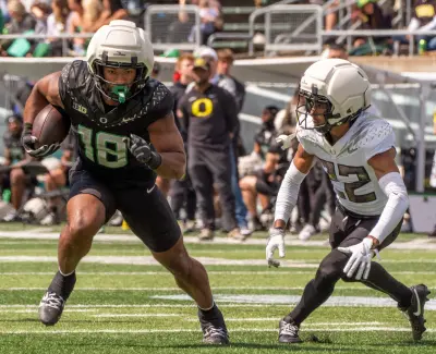 Combat Duck Kenyon Sadiq, left, runs ahead of Fighting Duck defender Jadon Canady during the second half of the Oregon Spring game.