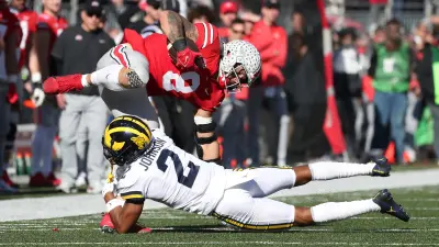 Michigan defensive back Will Johnson (2) tackles Ohio State tight end Cade Stover during the first half at Ohio Stadium in Columbus on Nov. 26
