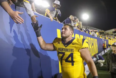 Sep 7, 2024; Morgantown, West Virginia, USA; West Virginia Mountaineers offensive lineman Wyatt Milum (74) celebrates with fans after defeating the Albany Great Danes at Mountaineer Field at Milan Puskar Stadium.