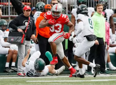 Ohio State Buckeyes running back Master Teague III (33) runs over Michigan State Spartans linebacker Cal Haladay (27) and tries to avoid cornerback Ronald Williams (9) during the third quarter of the NCAA football game at Ohio Stadium in Columbus on Saturday, Nov. 20, 2021. 