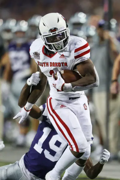 Sep 3, 2022; Manhattan, Kansas, USA; South Dakota Coyotes running back Shomari Lawrence (1) is tackled by Kansas State Wildcats safety VJ Payne (19) during the third quarter at Bill Snyder Family Football Stadium. Mandatory Credit: Scott Sewell-Imagn Images