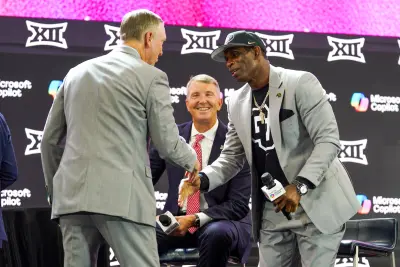 Jul 9, 2025; Frisco, TX, USA; Houston head coach Willie Fritz shakes the hand of Colorado head coach Deion Sanders on stage while Arizona head coach Brent Brennan looks on during 2025 Big 12 Football Media Days at The Star.